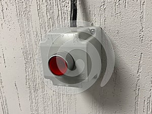 Red emergency button on a white wall