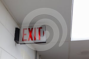 red emergency exit sign in the dark room. illuminated office exit sign