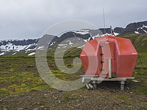 Red emergency shelter cabin in hloduvik campsite standing on the photo