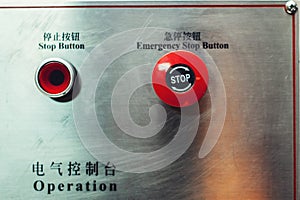 Red emergency stop button, inscriptions in English and Chinese