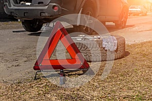 Red emergency stop sign warning sign of a red triangle and a broken car on the road. close-up of the red emergency