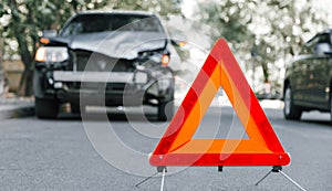 Red emergency stop triangle sign on road in car accident scene. Broken SUV car on road at traffic accident. Car crash traffic