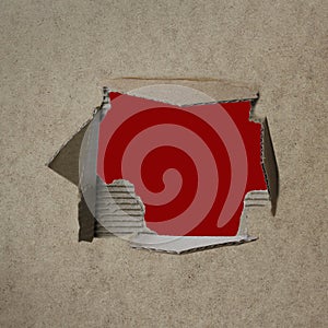 Red empty blank cardboard form, craft paper, a hole with a straight cut and roughly torn edge, concept of secrecy, tracking,