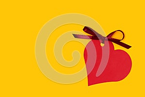 Red empty tag in a heart shape with tied ribbon bow.