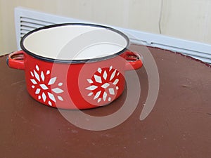 Red enamel pan with white painted flowers