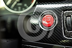 Red engine start button detail. Car dashboard with focus on red engine start stop button