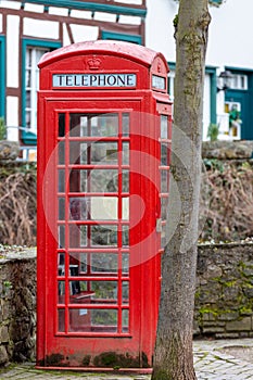 Red english telephone booth in front of a stone wall in Bad Muenstereifel