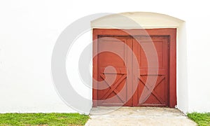 Red entrance door on a white fence