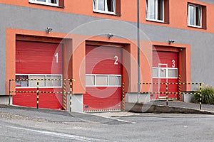 Red entrance gates to a fire station where the fire trucks are parked and ready for emergency situation