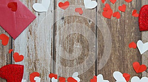 Red envelope, red and white hearts on a wooden background. Copy space. Festive background. Background for design. Top view