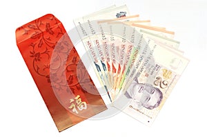 Red envelope with Singapore money notes side by side