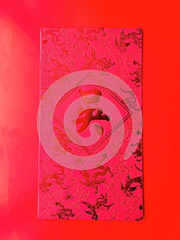 A red envelope with the surname \'Wu\' written in Chinese characters and some dragon designs on red background.