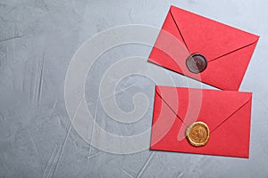 Red envelopes with wax seals on grey background, flat lay. Space for text