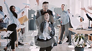 RED EPIC-W Happy beautiful young office worker woman throwing paper in air celebrating success with team slow motion.