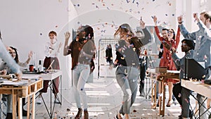 RED EPIC-W Happy young multiethnic female colleagues celebrate success with team and confetti at office slow motion.