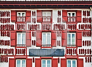 Red Espelette peppers drying in the wall of Basque house photo