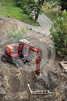 Red excavator digging a pit
