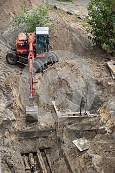 Red excavator digging a pit