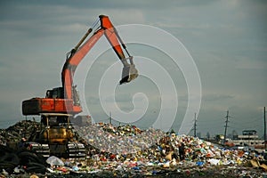 Red excavator in dumpsite