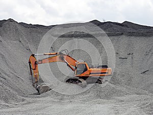 Red excavator in the quarry for loading aggregates photo