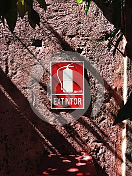 Red extinguisher sign on wall