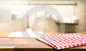 Red fabric,cloth on wood table top on blur kitchen counter roombackground