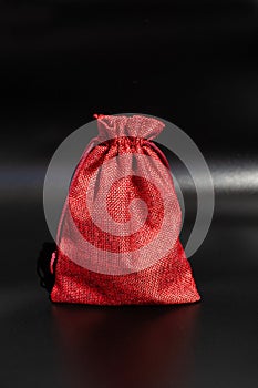 Red fabric drawstring bag on black background