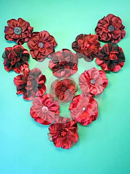 Red fabric flower brooch on green background