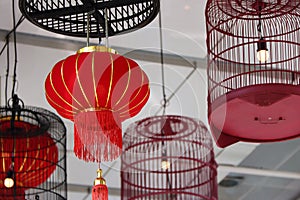 Red fabric lamps and bird cage lamps hanging on the ceiling.