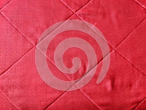 Red fabric from a plaid or blanket and embroidered cages. Background, texture, pattern, frame, copy space and place for