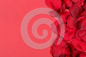 Red fabric rose petals border over red background top view from above - marriage, love, wedding or valentine`s day background