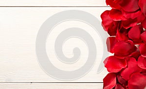 Red fabric rose petals border over white wood table background top view from above - marriage, love, wedding or valentine`s day