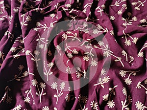 The background and pattern of the fabric is red with a simple flower image