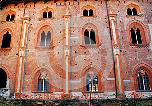 Red facade with nine wonderful mullioned windows in the castle of Vigevano near Pavia in Lombardy (Italy) photo