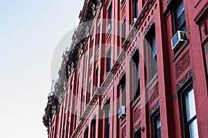 Red facade of a typical Harlem brownstone building, Manhattan, New York City, NY, USA