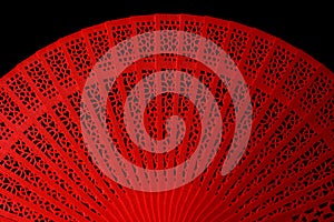Red fan with a pattern. Isolate on black background