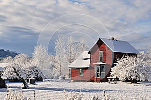 Red farmhouse with fresh winter snow and frost