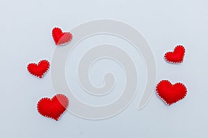 Red felt heart with white stitches. A symbol of love handmade sewn with thread around the edge on a white background