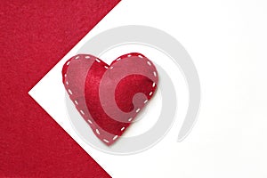 Red felt heart with white stitches on a white background. Happy Valentine\'s day.