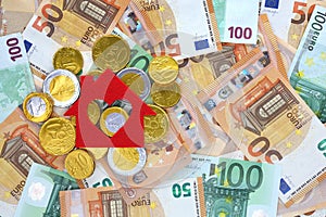 Red felt small house on chocolate euro cents coins, euro banknotes background. Real estate loan concept.