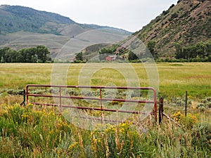 Red fence gate by a prairie