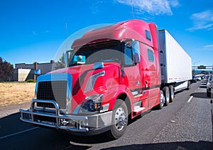 Red fency big rig semi truck modern trailer interstate highway