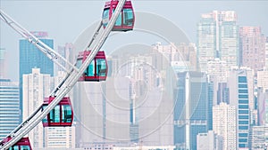 Red Ferris wheel against cloudy blue sky. Close up sky wheel in Hong Kong. City scape.