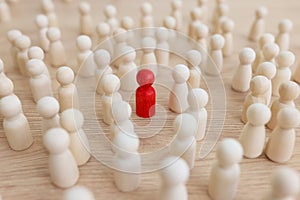 Red figure stands out of crowd with white figurines on table