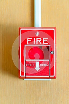 red fire alarm handle on wooden backdrop
