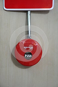 Red fire alarm push button on the wall.