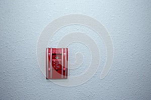 Red fire alarm switch on blue wall background