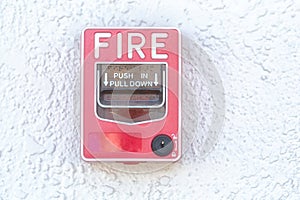 Red fire alarm switch at cement wall