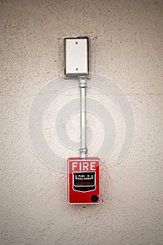 Red fire alarm switch at white wall