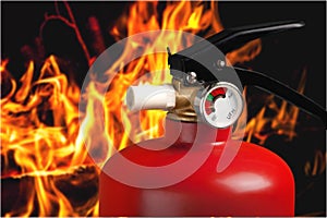 Red fire extinguisher and flames, close-up view